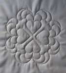 Four hearts arranged ointing ourtwards, surrounded by plumes of feathers