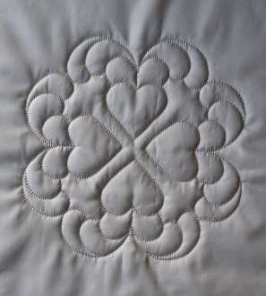 Four hearts arranged ointing ourtwards, surrounded by plumes of feathers