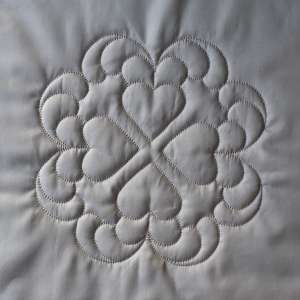 Four hearts arranged ointing ourtwards, surrounded by plumes of feathers